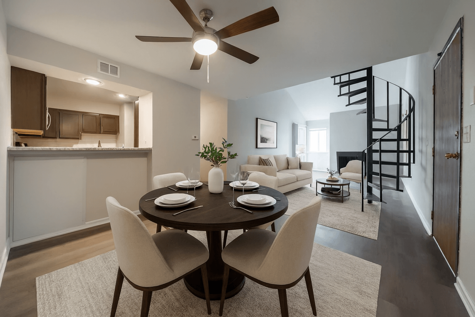 A dining room with a round table and chairs.